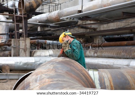 Yong worker in uniform is repairing the trunk pipeline