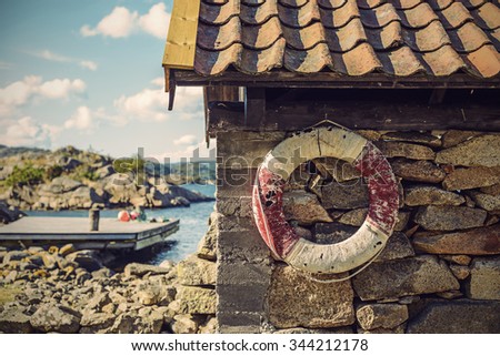 lifebelt at an old boatshouse, vintage filtered style, Norway, Europe Royalty-Free Stock Photo #344212178