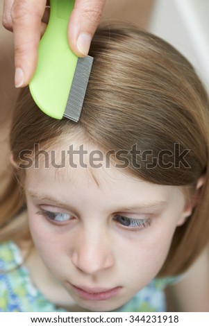 Mother Checking Daughters Hair For Head Louse