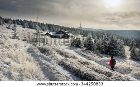 Hiking in Jeseniky, Czech mountains in winter time, hut Svycarna and tower Praded in the distance