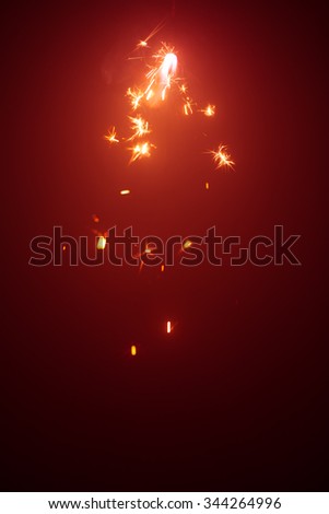 Christmas sparkler in haze with red light