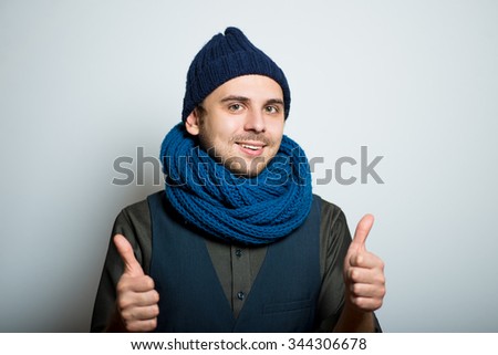 young business man showing everything is OK, winter fashion, studio shot isolated on the gray background