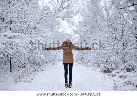 girl in warm clothes in the winter is snowy forest