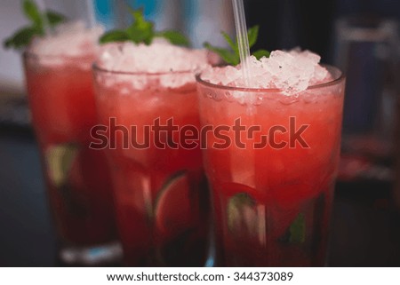 Beautiful row line of different colored alcohol cocktails with mint on a christmas party, martini, vodka with bubbles,and others on decorated catering bouquet table on open air event, picture 