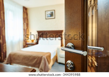 Hotel room or apartment doorway with open door and bedroom in background Royalty-Free Stock Photo #344395988