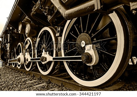 Old german steam locomotive, built in 1940, in a museum. The heaviest locomotive, 85 tons, that circulated in Romania during the Second World War. Detail and close up of huge wheels. Sepia processing. Royalty-Free Stock Photo #344421197