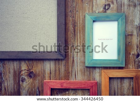 picture frames of different colors and wooden background