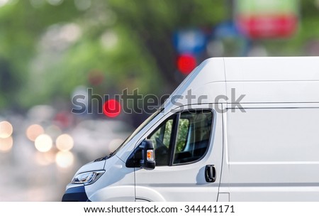 Fast delivery, van on city street blured bokeh background Royalty-Free Stock Photo #344441171