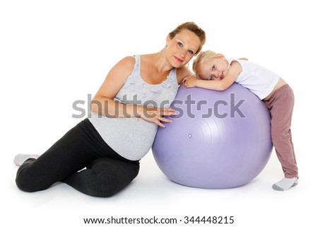 Young pregnant woman and small daughter with fitness ball on a white background. Healthy family.
