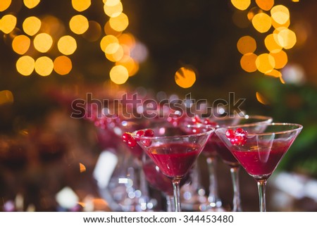 Beautiful row line of different colored alcohol cocktails with mint on a christmas party, martini, vodka with bubbles,and others on decorated catering bouquet table on open air event, picture 