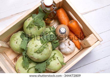 Kohlrabi cabbage, carrots, garlic, salt and olive oil in a wooden box