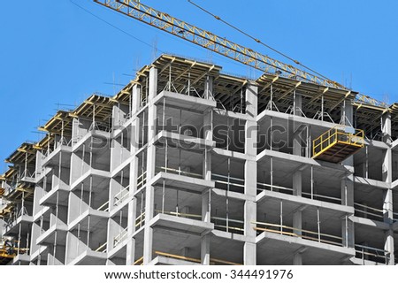 Crane and building construction site against blue sky Royalty-Free Stock Photo #344491976