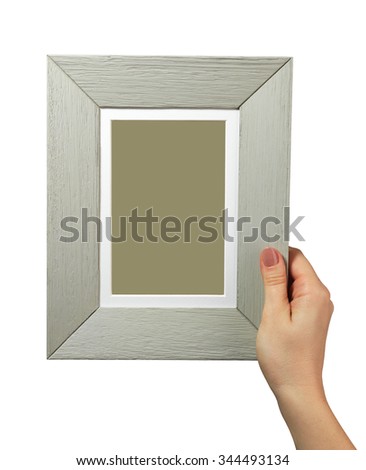 female hand holding a wooden frame isolated on white background. close up