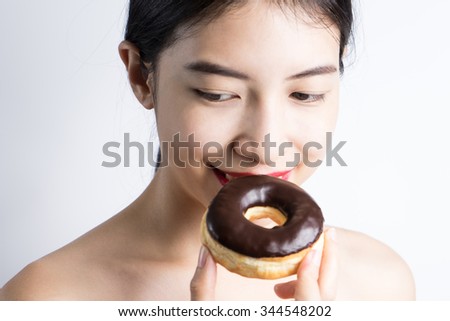 Woman eating donut on white background