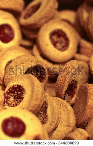Photo closeup many tasty round shortbread cookies filled with red fruit jam freshly baked desserts on blurred background, vertical picture