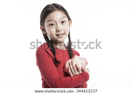 A asian(korean, japanese, chinese) girl(woman, female) make a pose with smile and hold a plastic pink pig coin bank(money box) to save money isolated white.