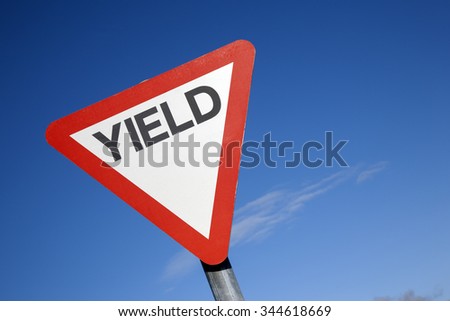 Red and White Yield Sign against a Blue Sky Background