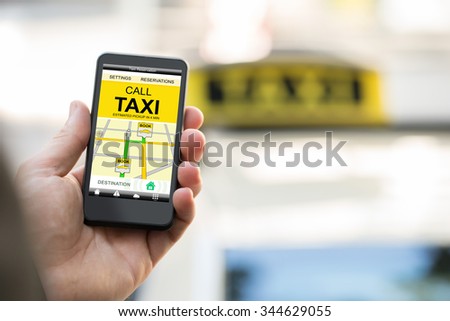 Close-up Of Person Booking Taxi On Smart Phone