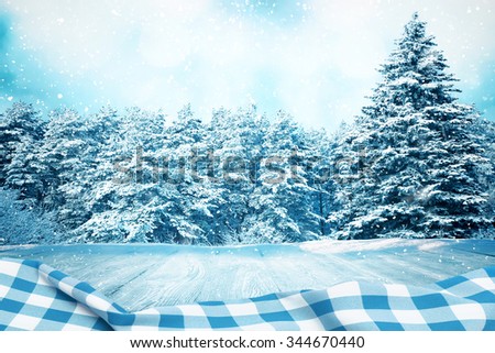 Picnic table in winter forest with blue tablecloth with space for your object