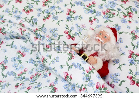 Santa under the blanket in a bed. Santa Claus.  Merry Xmas wintertime greeting card. Happy New Year 2016