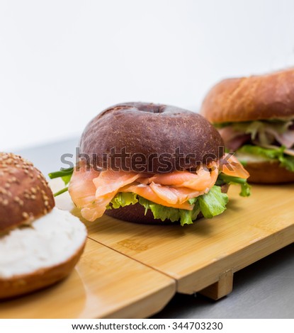 Burgers with fish on wooden plank on white background