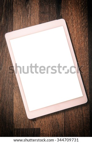 White blank screen on the tablet pc on wooden background 