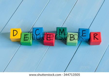 Word December On child's toy cubes on wooden rural  background