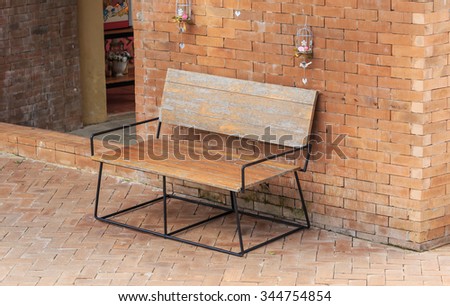 vintage wood bench beside red brick wall