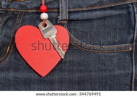 Jeans background with wooden heart and key. Texture Valentine's day.