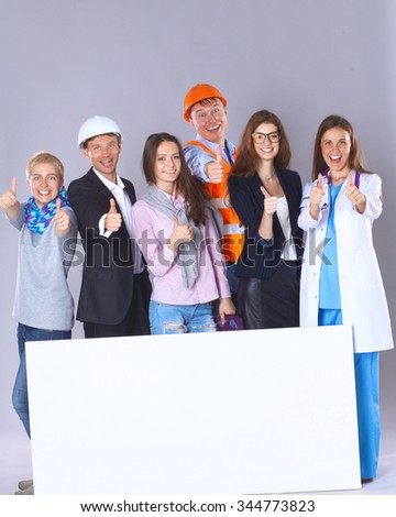 Portrait of smiling people with various occupations holding blank billboard showing ok
