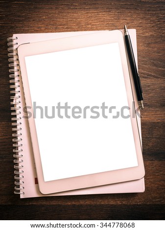 White blank screen on the tablet pc on wooden background for your ads 