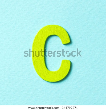 Wooden textured green color alphabet C in blue background