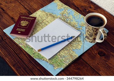 map, passport, notebook and cup of coffee on wooden table