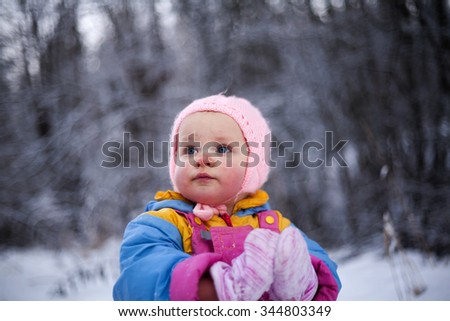 Portrait of a little girl with blush on cheeks from cold weather.