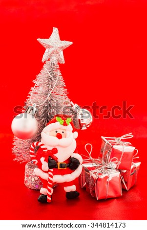 Santa and snow christmas tree with silver present on red background