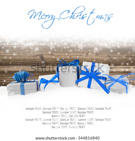 Photo of gifts with colorful ribbons, falling snow and white space
