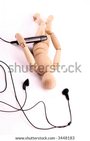 wooden model listens to music in headphones on white background