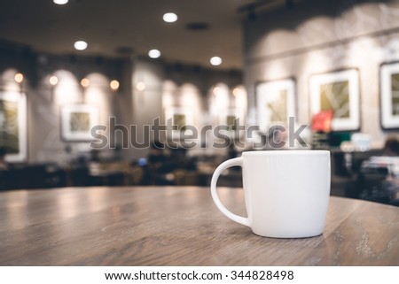 Soft focus on White coffee cup in coffee shop cafe on old wooden table in coffee shop - HDR Merge 3 photos and Vintage filter Processing style