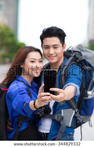 Happy tourists taking photo of themselves. summer holidays, travel, vacation, tourism and dating concept - couple taking photo picture with camera