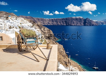 Decorative old cart with flowers on a roof terrace in Oia, Santorini, Greece