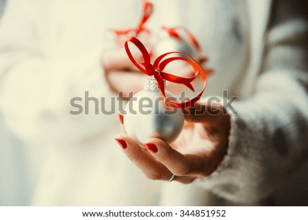 Woman's hands hold christmas tree glass balls. Holiday gift and decoration concept. Toned picture