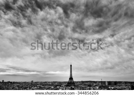 Paris, France skyline with Eiffel Tower under dark dramatic clouds. Black and white.