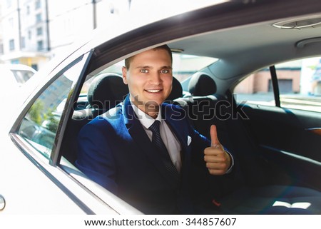 stylish confident young groom makes thumbs up sign