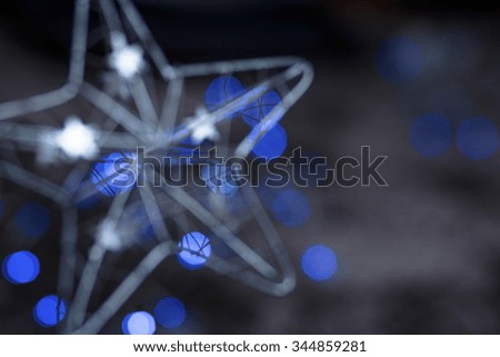 Detail Of Metallic Modern Christmas Star On Blue Tint Light Bokeh Background