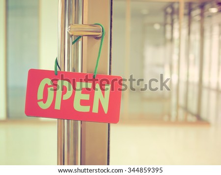 Open sign on a glass door in vintage style color effect.