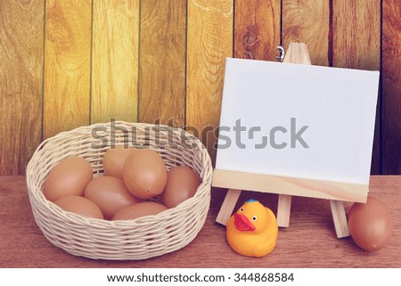 canvas frame and eggs in basket with wooden wall background
