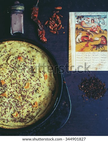 Oriental still life with homemade pie, spices and page of vintage book from Asia. Selective focus.