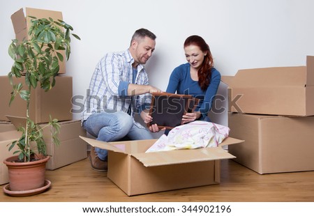 happy couple unpacking boxes in their new home