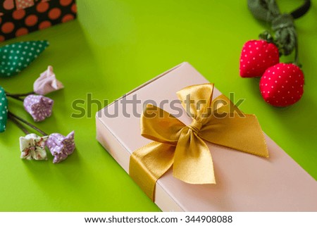 Composition of cute gift boxes and gold bow on green background