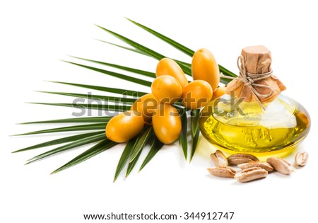 Date seed oil in a glass bottle, seeds and fruit with leaf isolated on white background